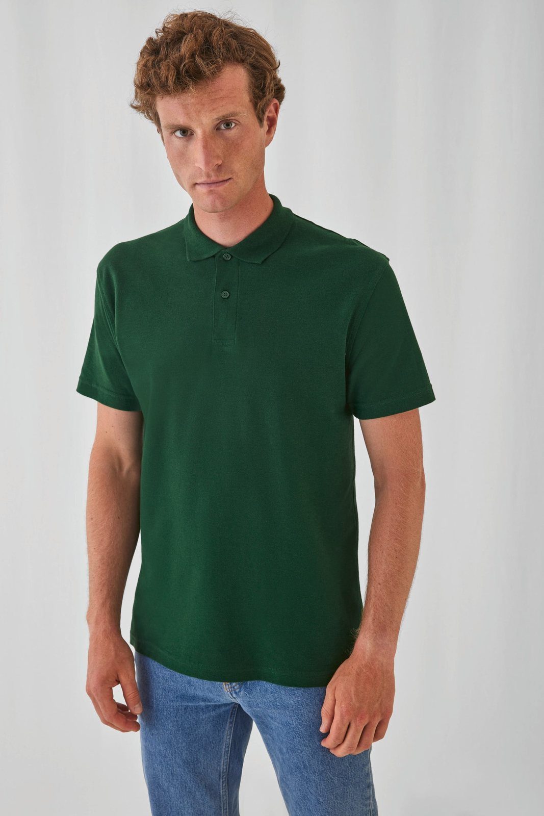 Man met rood krullend haar in een donkergroene polo