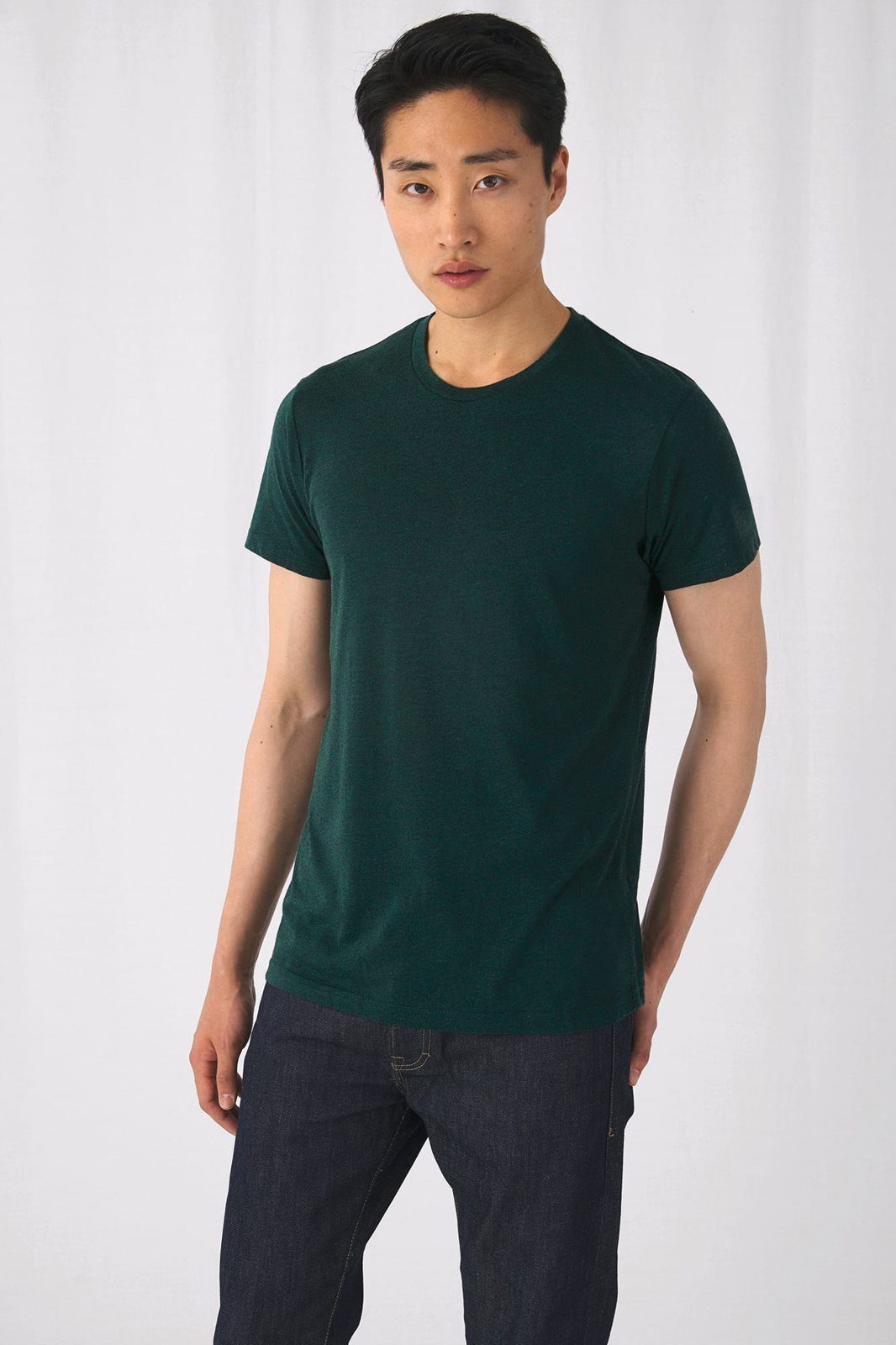Man in een donkergroen gemêleerd T-shirt en een donkere jeans