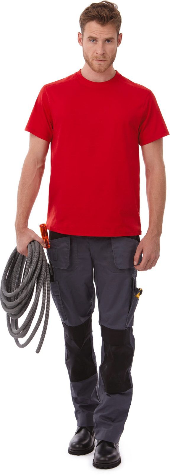 Man in een rood T-shirt en werkbroek met een kabelrol over zijn arm