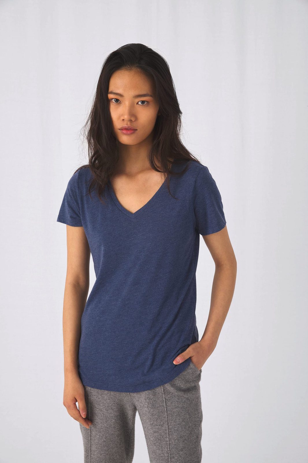 Vrouw in een gemêleerd donkerblauw T-shirt met V-hals