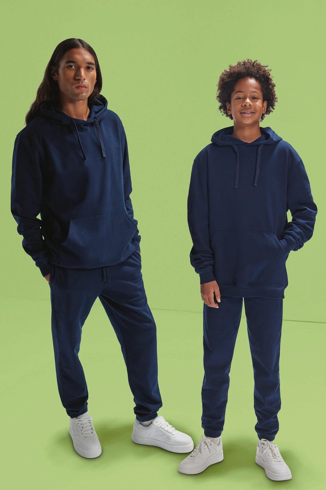 Man met lang haar en een kind in bijpassende donkerblauwe hoodies en joggingbroeken