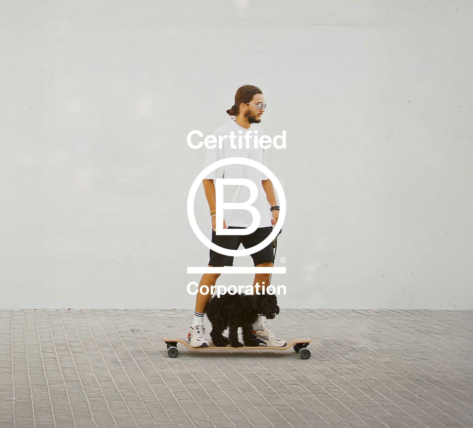 Persoon met een hond op een skateboard naast het logo van Certified B Corporation
