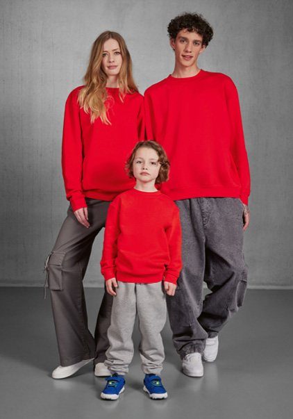 Twee volwassenen en een kind in rode sweaters