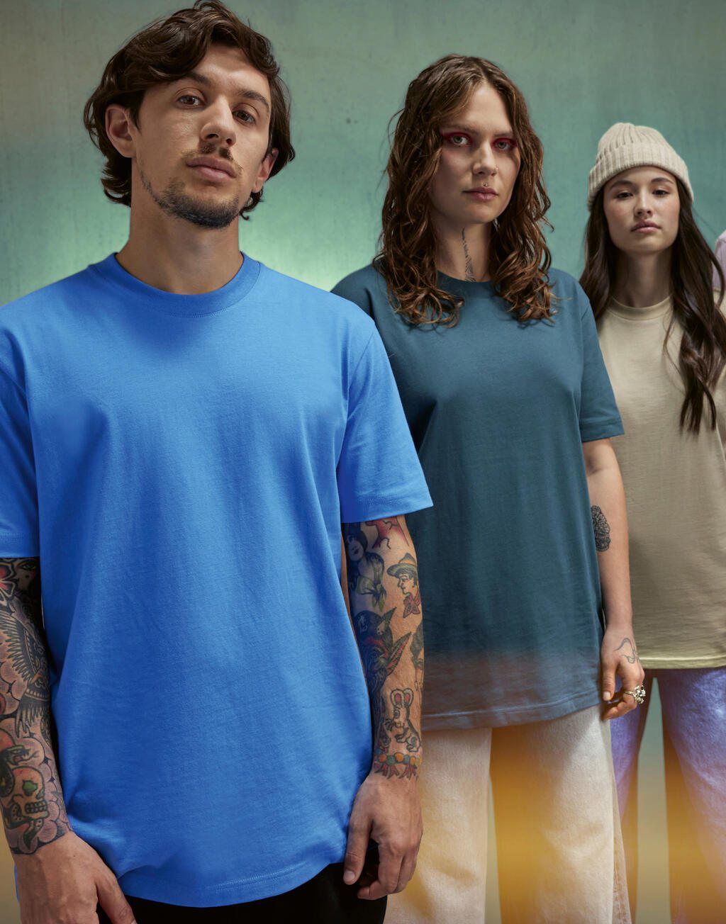 Drie mensen in T-shirts in blauw, petrol en zand