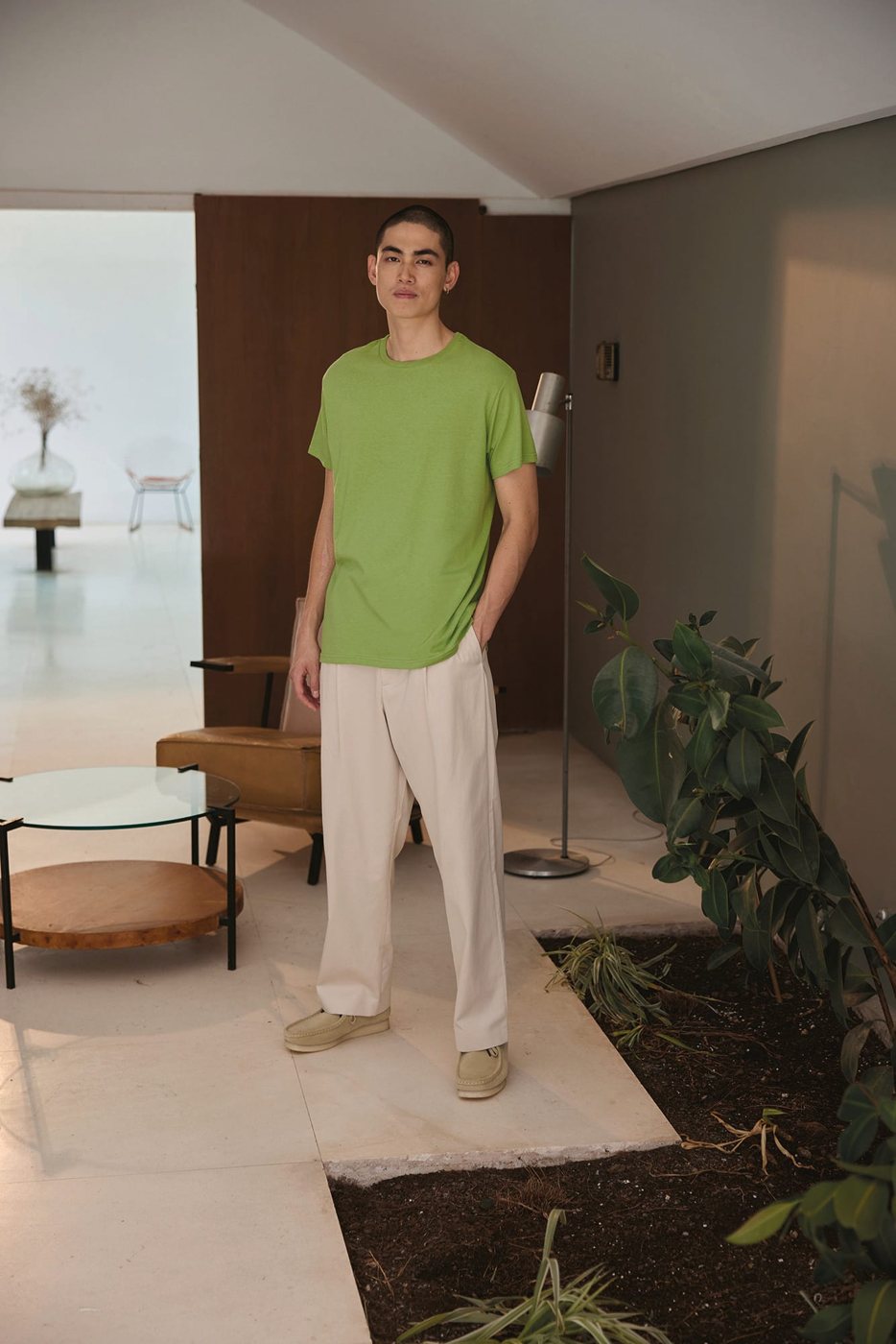Man in een limegroen T-shirt in een lichte woonkamer