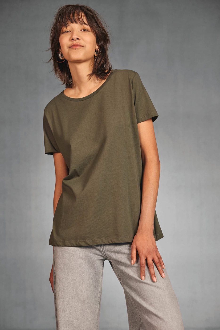 Vrouw in een kakigroen T-shirt en een lichte jeans