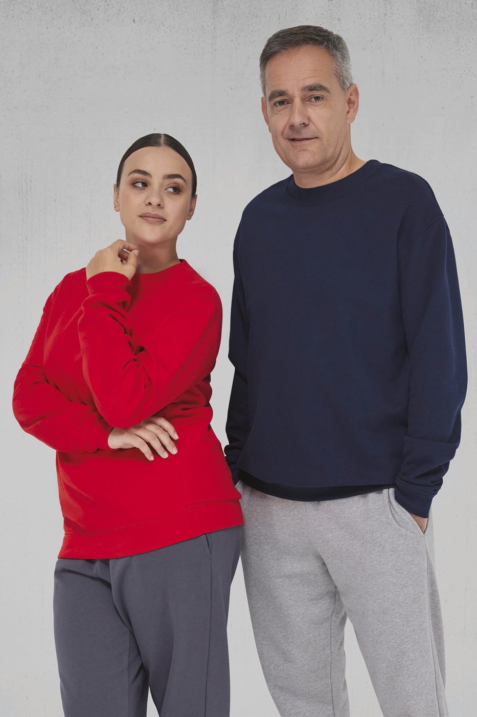 Jonge vrouw in een rode en oudere man in een navy sweater