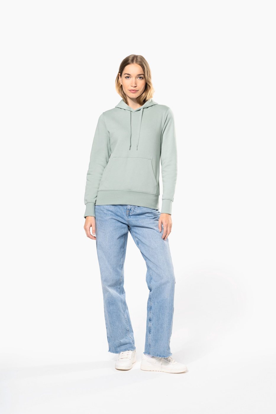 Woman in a mint green hoodie and wide jeans