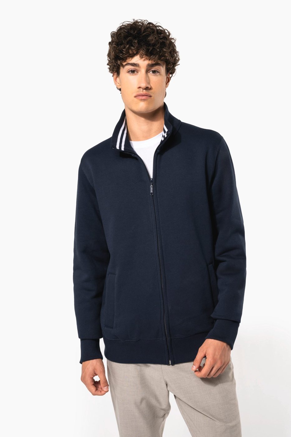 Man met krullen in een donkerblauw sweatvest met opstaande kraag