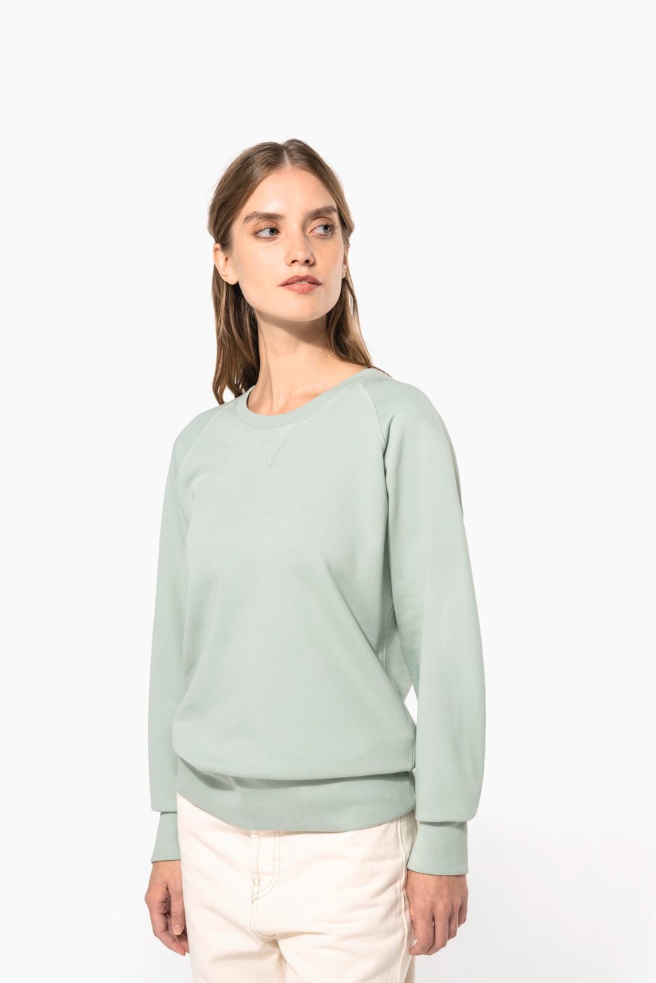 Vrouw in een saliegroene sweater met ronde hals