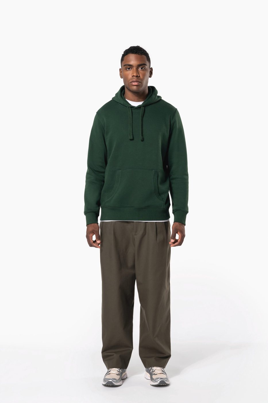 Man in a dark green hoodie with wide khaki trousers