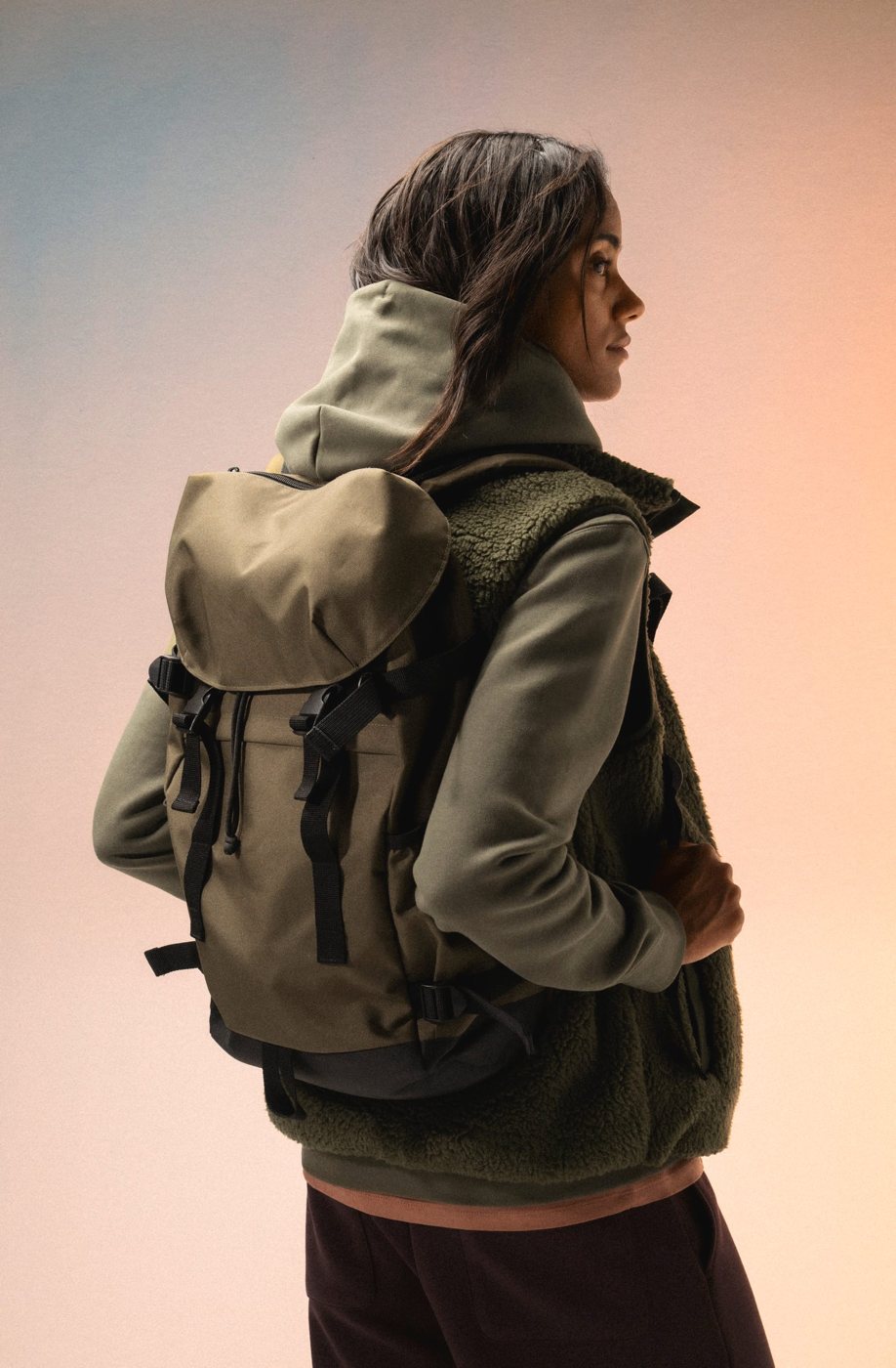 Woman with an olive green backpack, seen from behind