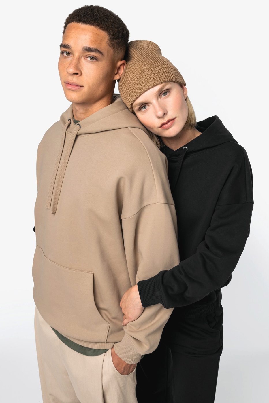 Two people in an oversized hoodie in sand and black