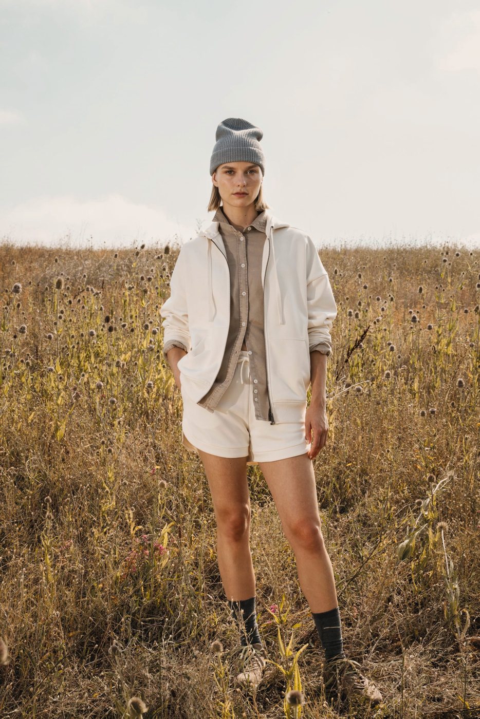 Woman in a cream-coloured hoodie waistcoat in a field