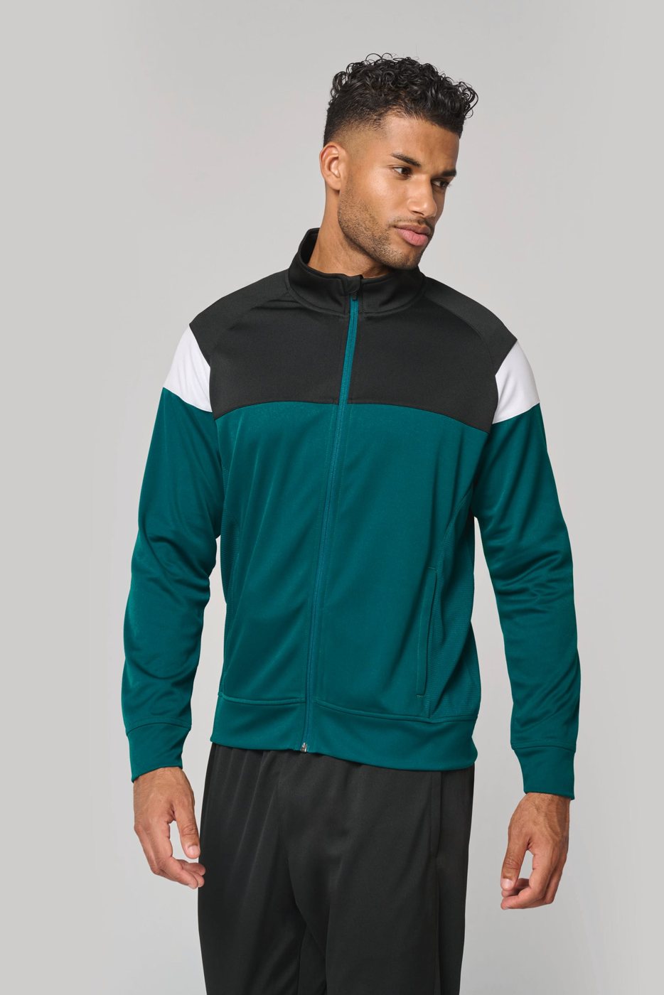 Man in a green track jacket with black shoulders