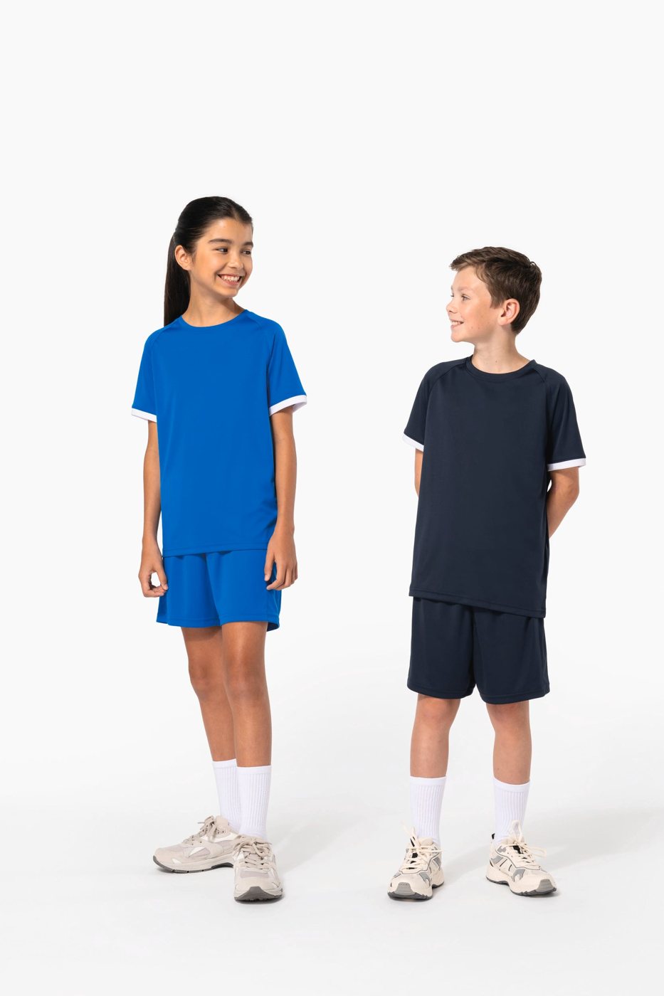 Meisje in een blauw en jongen in een donkerblauw sporttenue met shirt en short