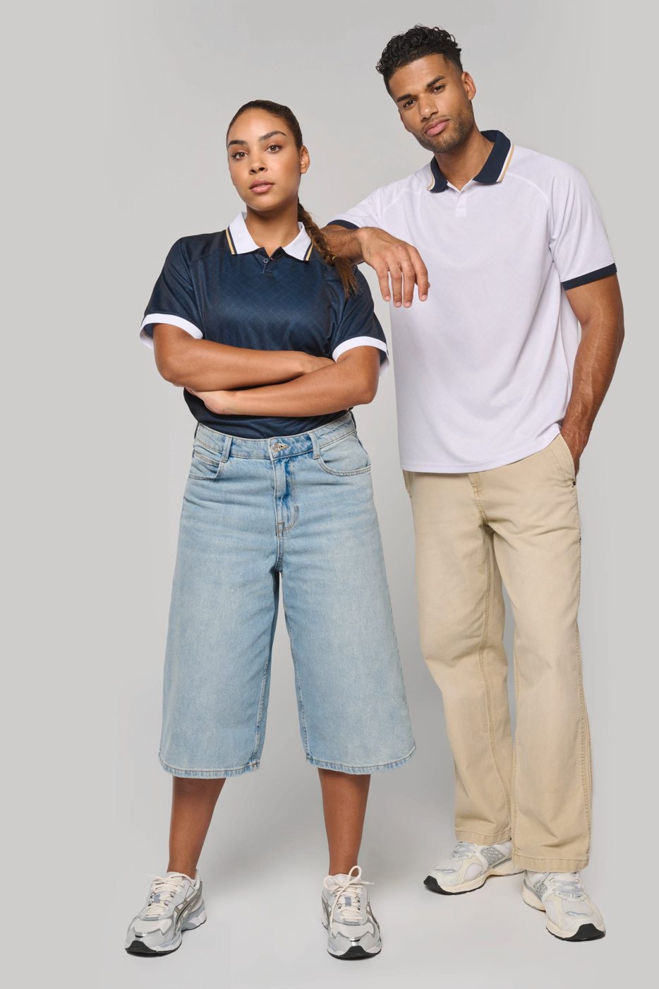 Woman in a navy and man in a white sports polo with contrast collar