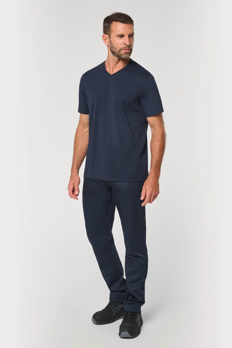 Man in een donkerblauw T-shirt met V-hals en donkere werkbroek
