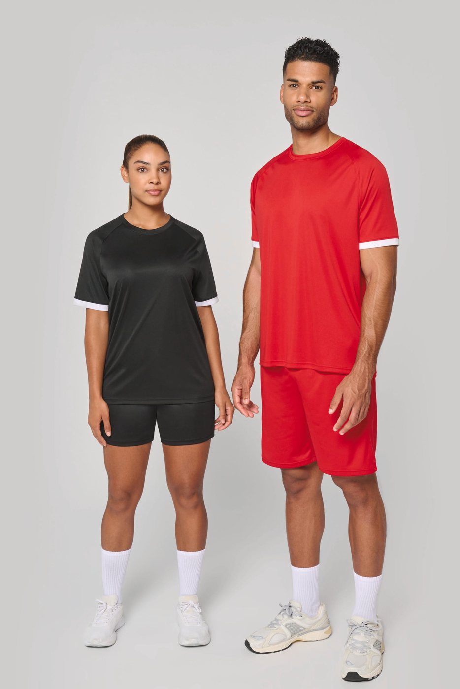 Woman in a black and man in a red sports shirt with white cuffs and matching sports shorts