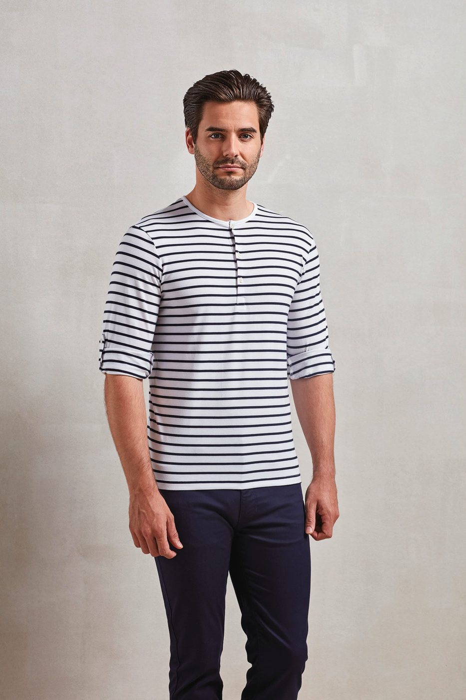 Man in een wit-navy gestreept T-shirt met knoopjes en opgerolde mouwen