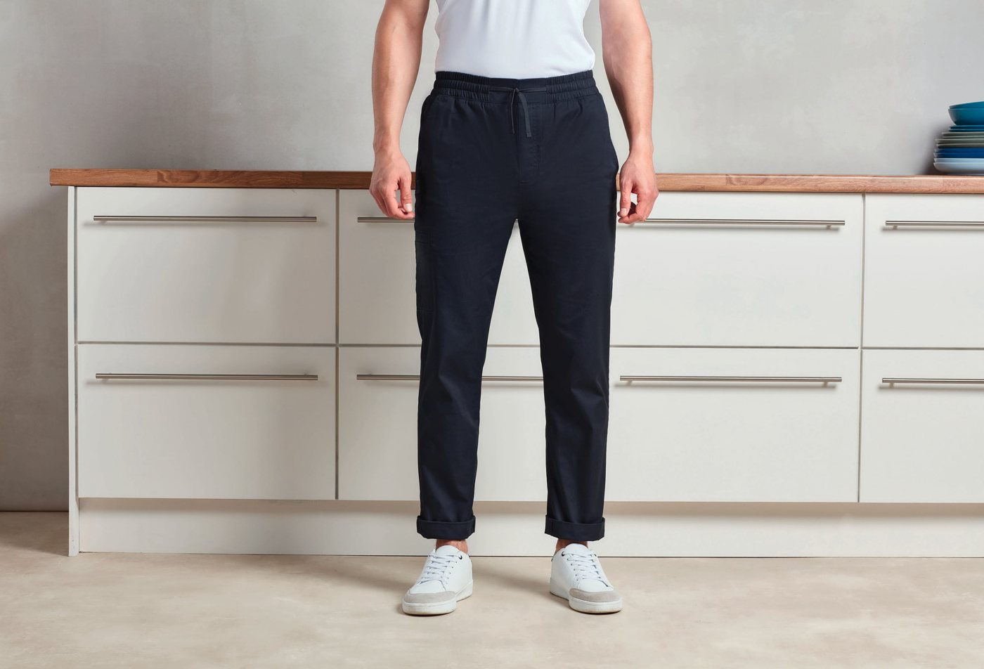 Donkerblauwe cargobroek met elastische taille en witte sneakers, voor een keukenblok