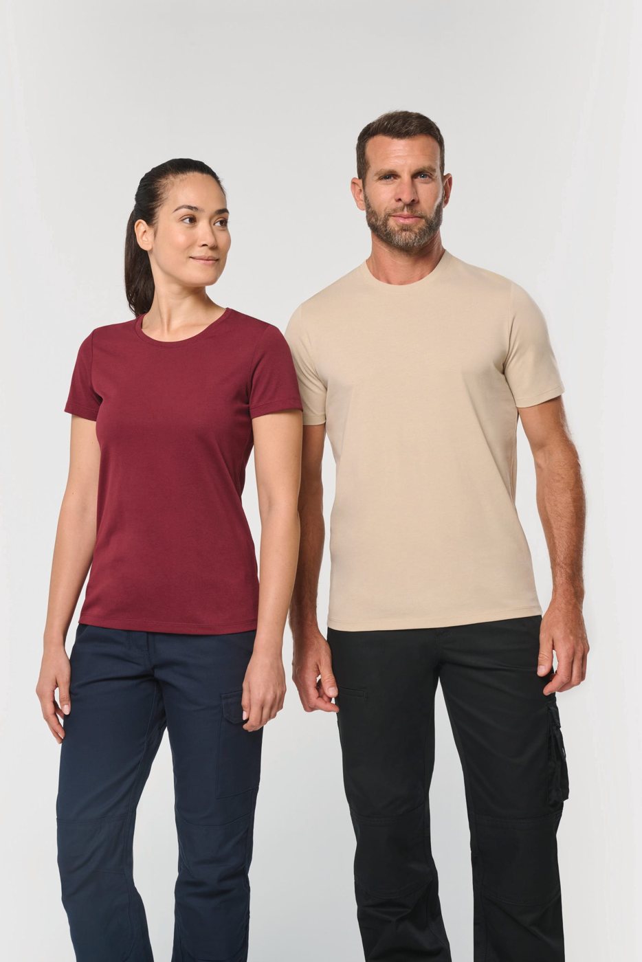 Vrouw in een wijnrood en man in een zandkleurig werk-T-shirt met ronde hals