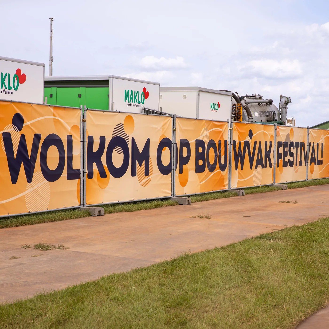 Bedrukte bouwhekdoeken langs een festivalterrein
