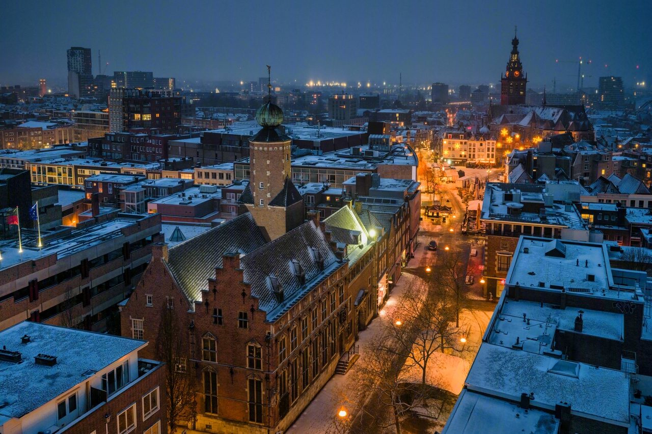 De binnenstad van Nijmegen bij avond, van bovenaf gezien met verlichte winkelstraten
