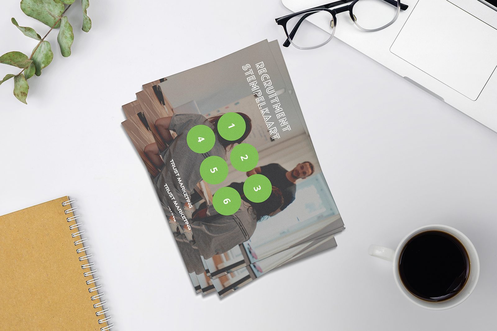 Stapeltje zakelijke flyers naast een notitieboek en een kop koffie