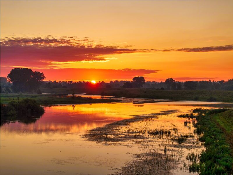 Stil water, oranje lucht Geen wind, geen golfjes