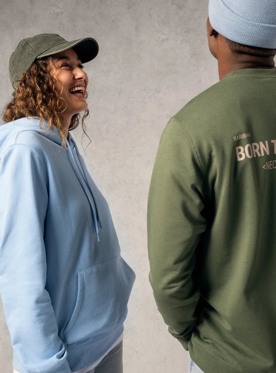 Twee mensen in Kariban-hoodies, een met een rugprint