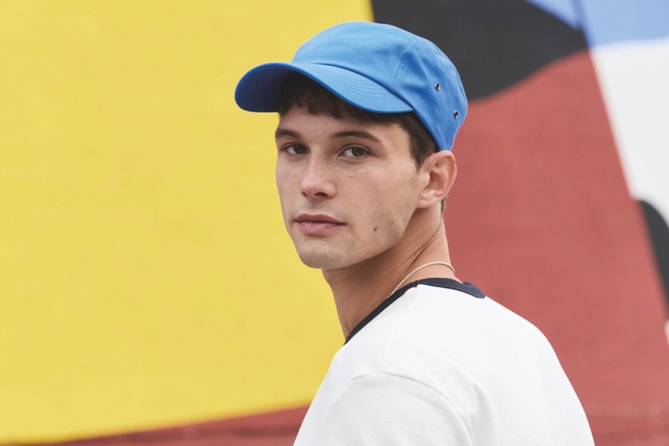 Jongen met een blauwe pet en een wit Kariban-shirt