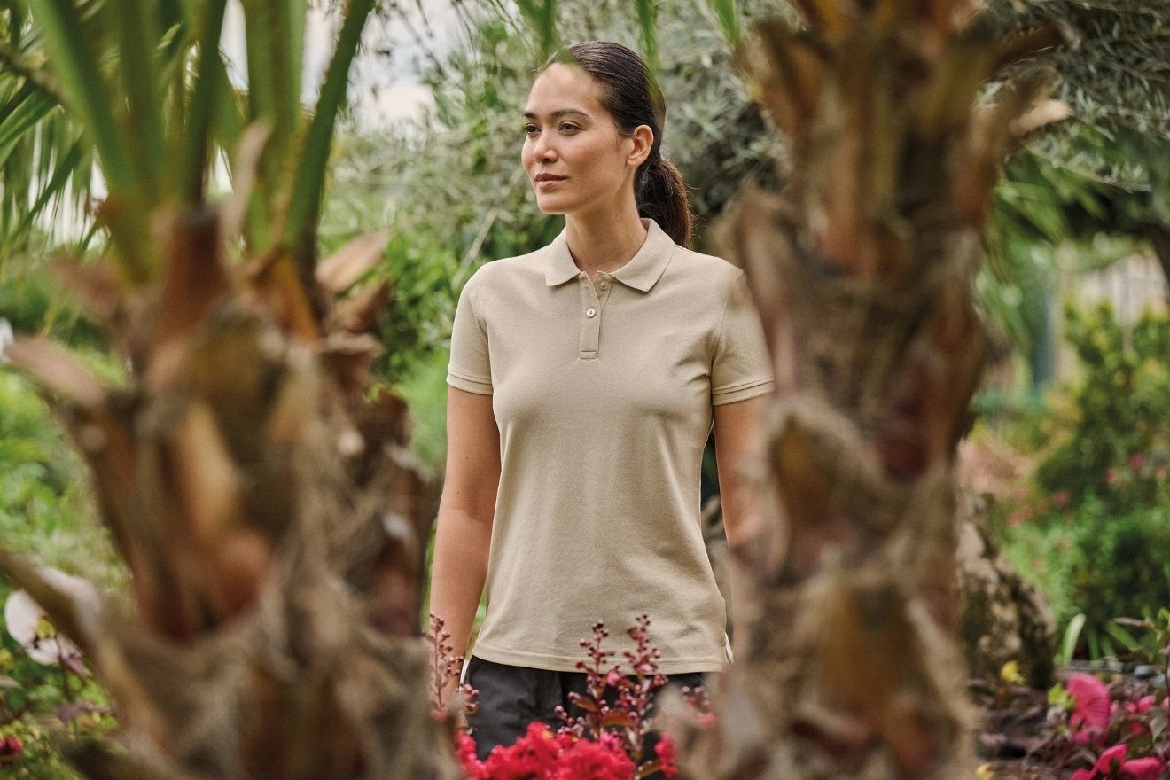 Vrouw in een beige polo tussen planten
