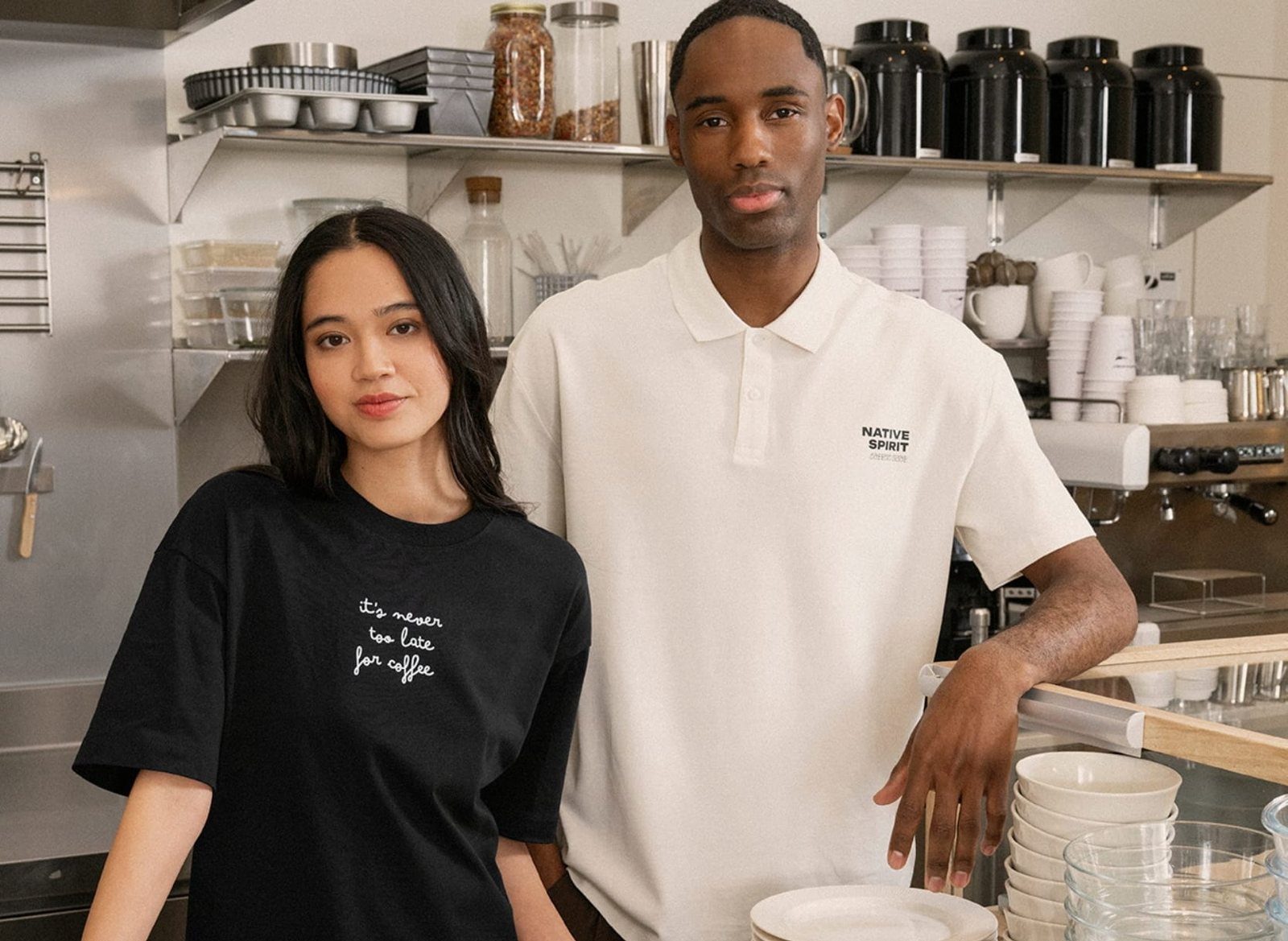 Twee medewerkers in een bedrukt shirt en polo in een keuken