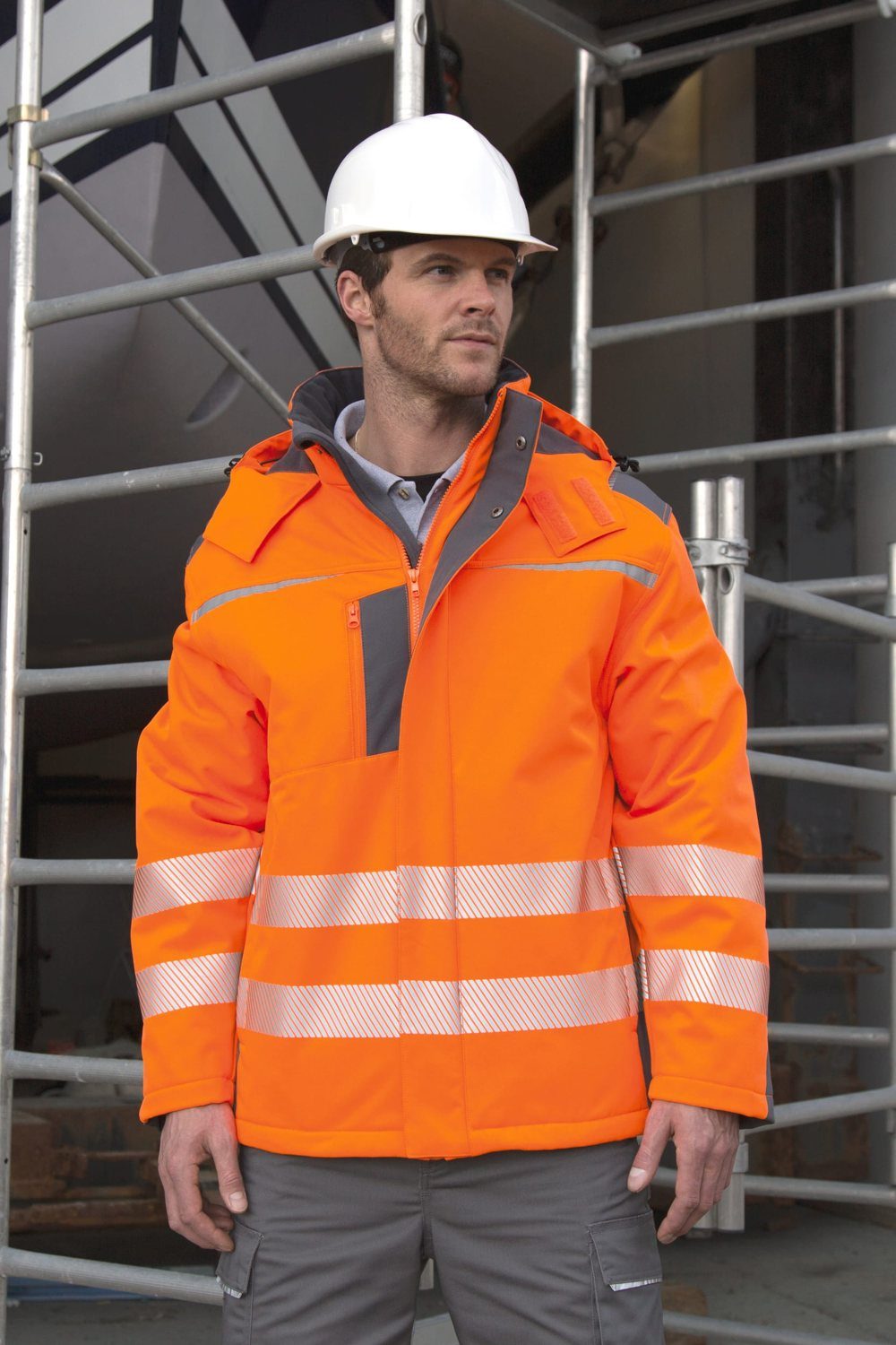 Man met helm in een oranje hi-vis werkjas