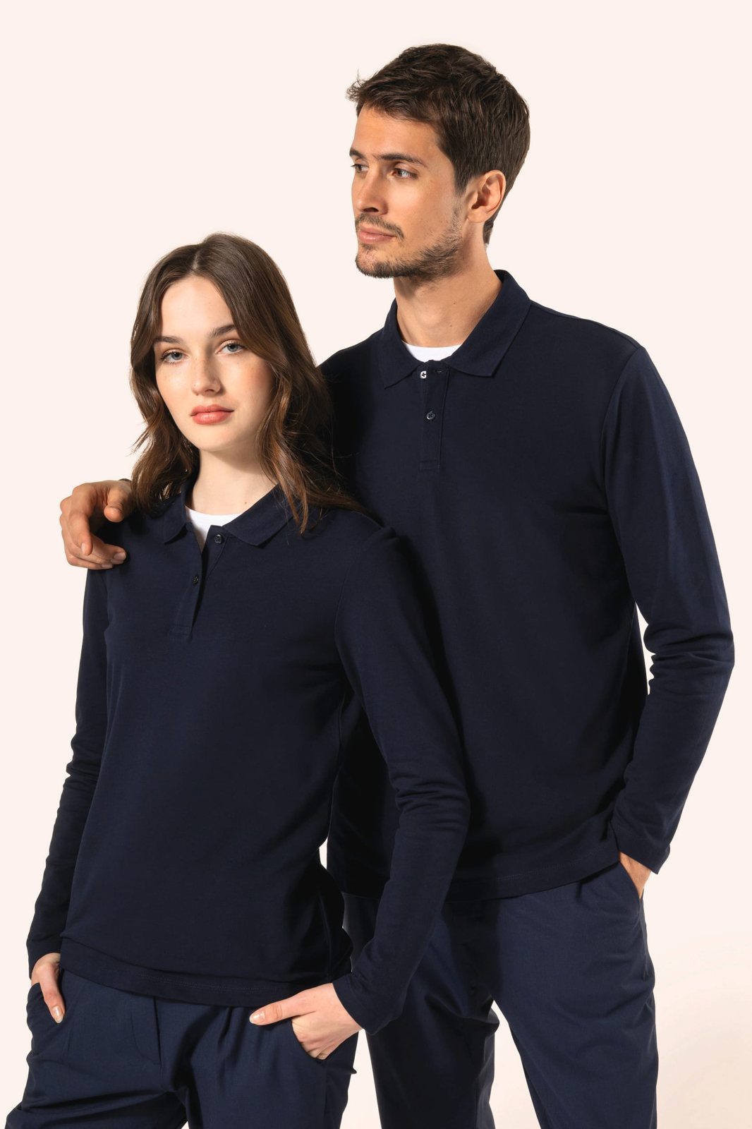 Man with his arm around a woman, both in a navy long-sleeved polo