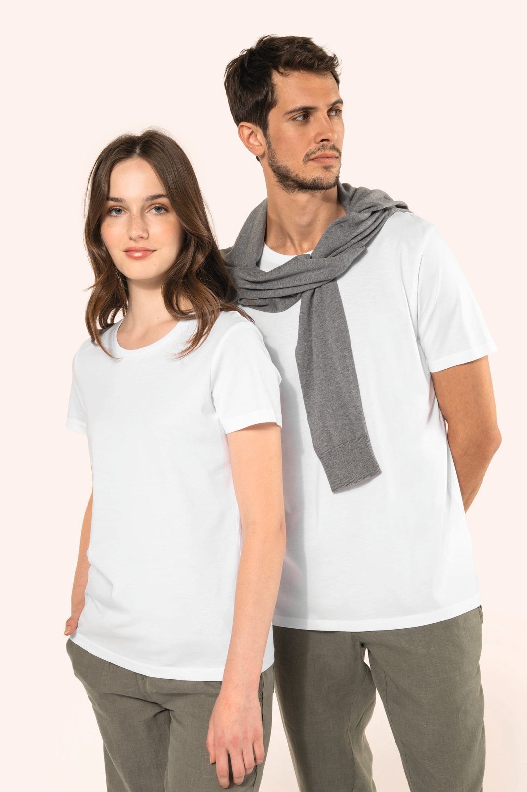 Woman and man in a white T-shirt, he with a grey jumper over his shoulders