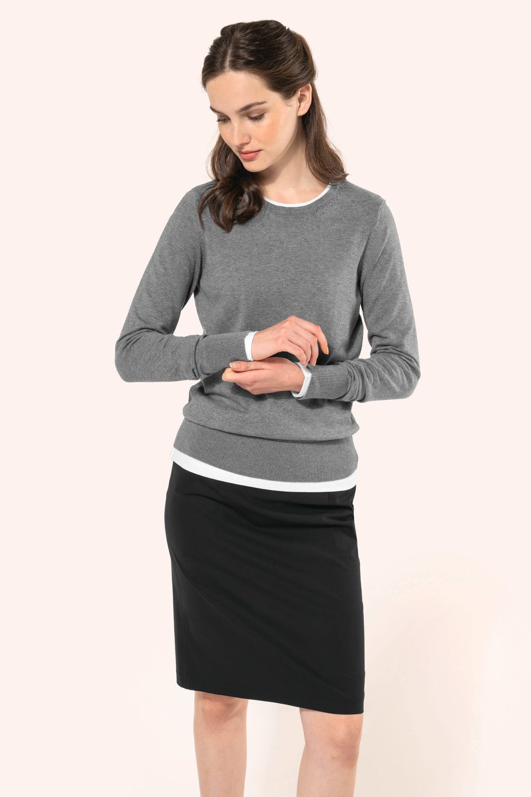 Woman in a grey jumper and a black straight skirt