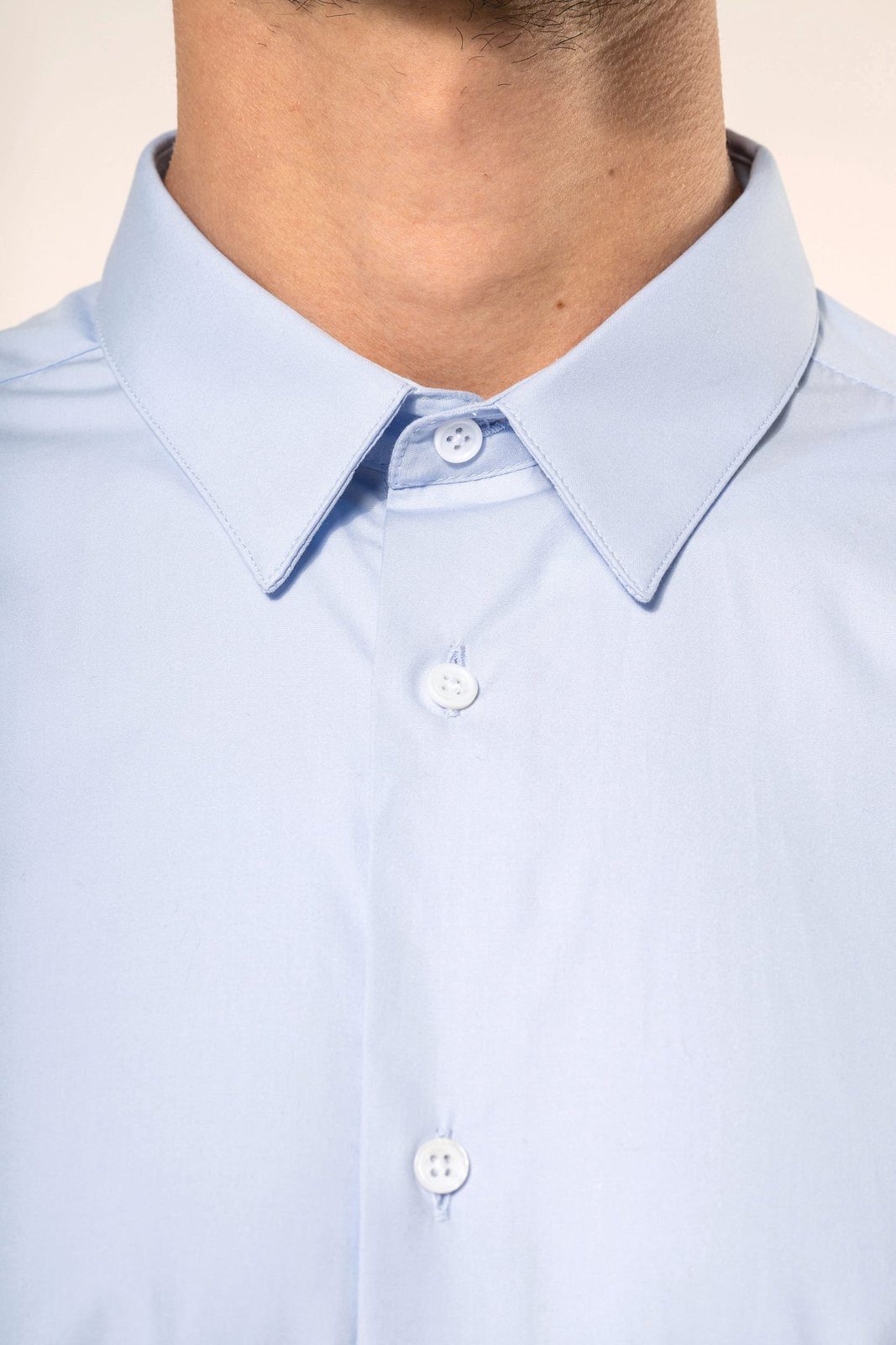 Close-up of the collar of a light blue poplin shirt