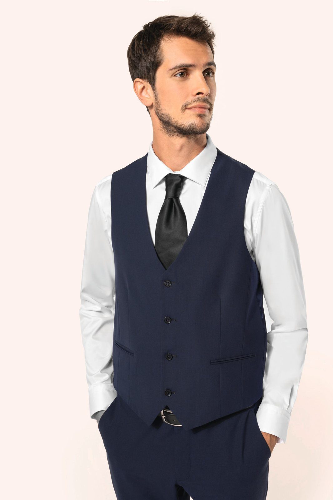 Man in a dark navy gilet with a white shirt and black tie