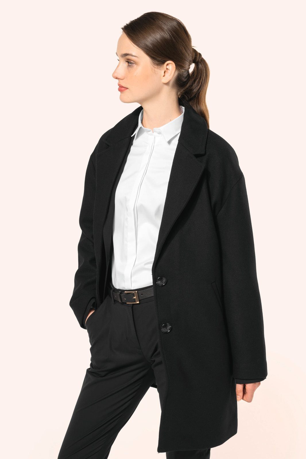 Woman in a long black coat over a white shirt