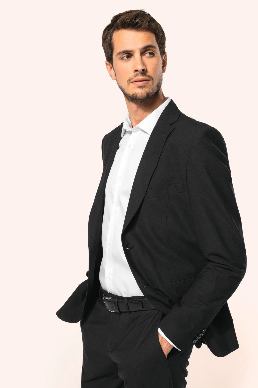 Man in a black blazer with a white shirt, hand in pocket