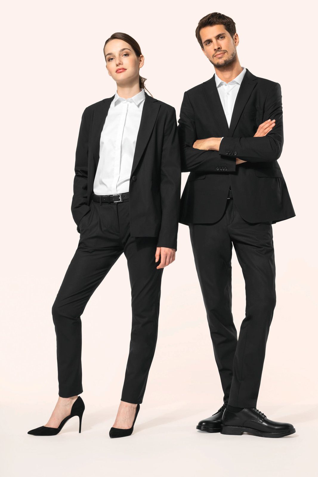 Woman and man in a black suit with white shirt, he with arms crossed