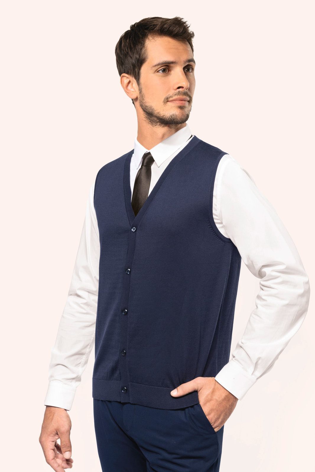 Man in a navy gilet with a white shirt and tie