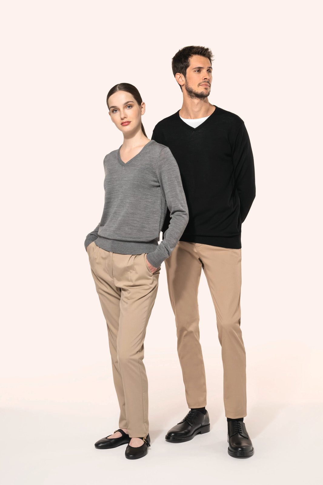 Woman and man in a merino jumper with a V-neck and beige trousers