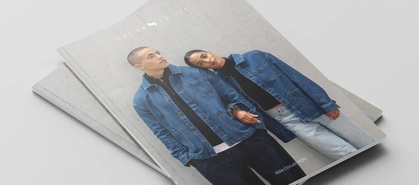 Stel in denim jassen, zittend bij een stapel catalogi