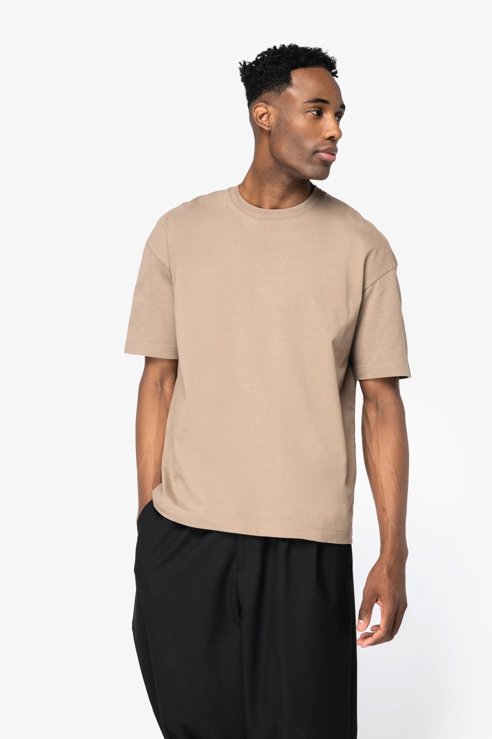 Man in een beige oversized T-shirt