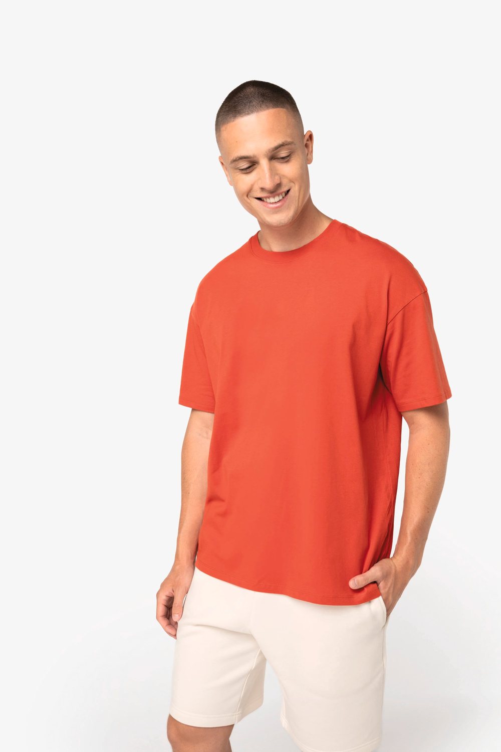 Man in een rood oversized T-shirt, van opzij