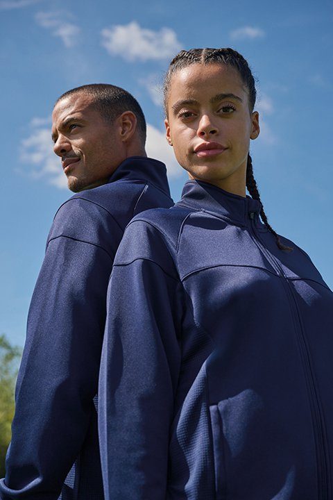 Twee sporters in een navy Proact Premium-trainingsjasje, van achteren