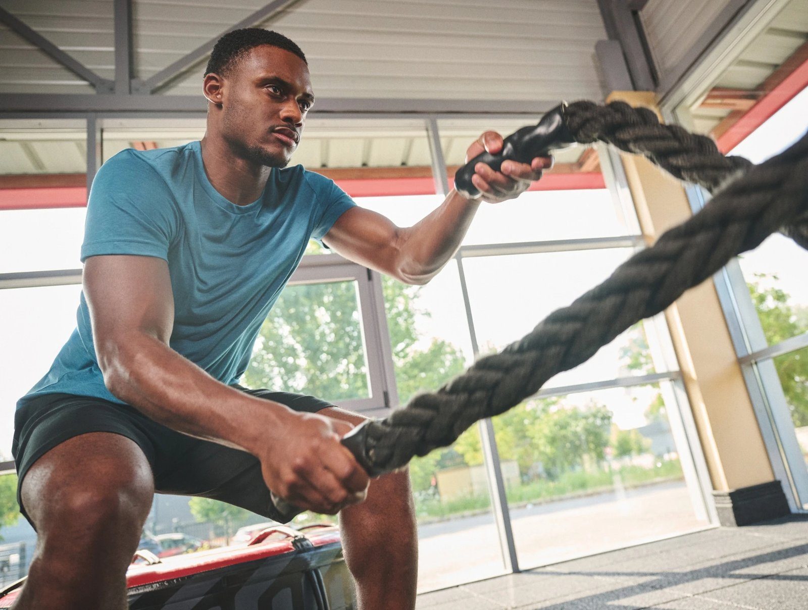 Man traint met battle ropes in een Proact Triblend-shirt